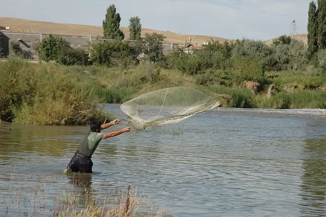 lancer d'un filet de pêche par un pêcheur à pied